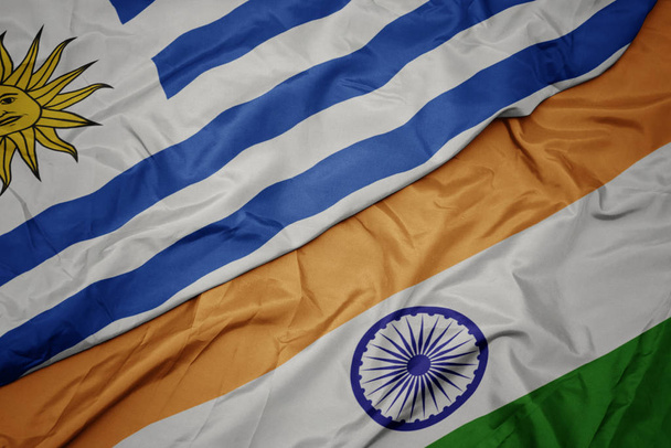 ondeando colorida bandera de la India y bandera nacional de uruguay
. - Foto, Imagen