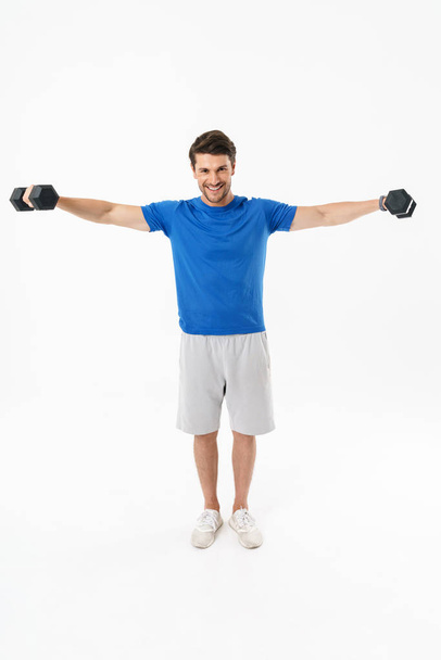 Full length photo of happy sportsman in shorts and t-shirt lifti - Фото, зображення