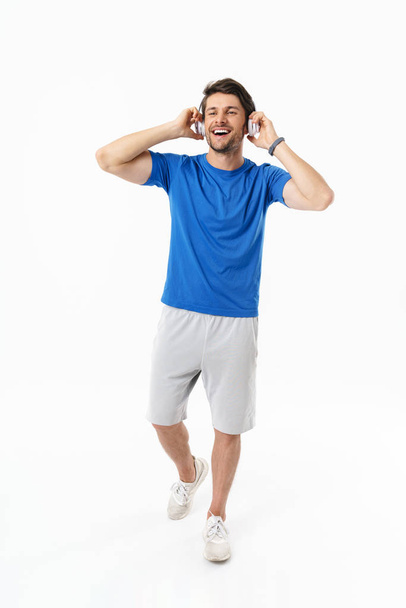 Full length photo of brunette man in casual t-shirt smiling whil - Фото, изображение