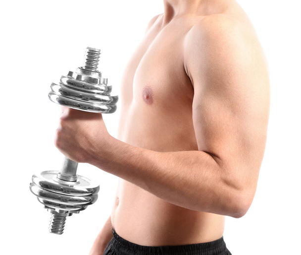 Handsome young muscular sportsman execute exercise with dumbbell, isolated on white - 写真・画像