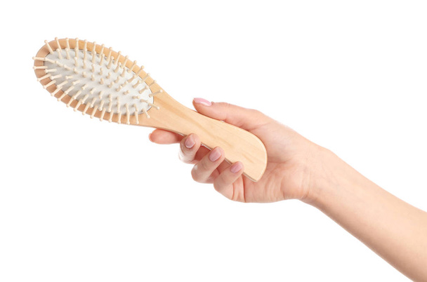 Woman holding wooden hair brush against white background, closeup - Foto, Imagen