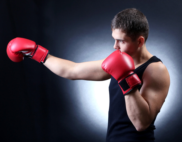 Handsome young muscular boxer on dark background - Фото, изображение