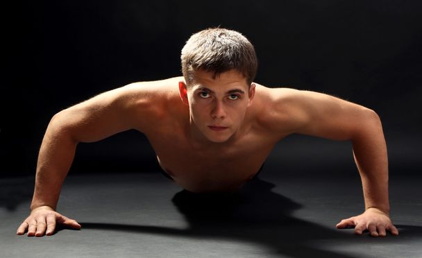 Handsome young muscular sportsman, on dark background - Photo, image