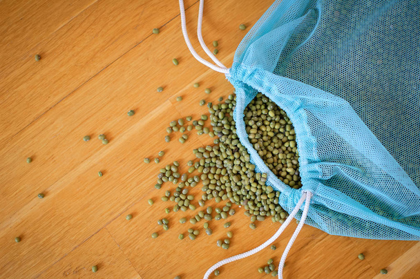 Pohled na zelenou Mungo fazole v modrém opakovaně použitelném balení na dřevěném podkladu. Koncepce zdravého stravování - Fotografie, Obrázek