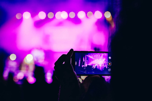 Persona que captura un vídeo en un teléfono móvil en un festival de música - Foto, imagen