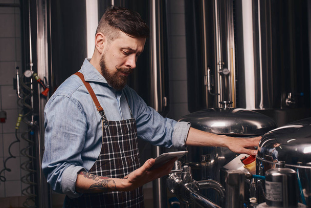 Bartender reads about the brewing processes. - Foto, Bild