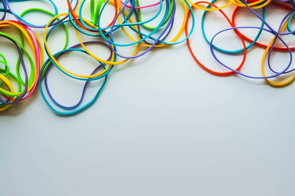Top view of colorful rubber bands isolated on white. Rainbow elastic rubber bands on white - 写真・画像