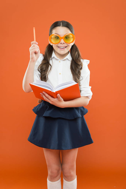 Happy little schoolgirl ready for lesson. Cute child with book. Only wisdom knowing you know nothing. Study foreign language. Study literature. Pupil likes study. Small girl enjoying her school time - Photo, image