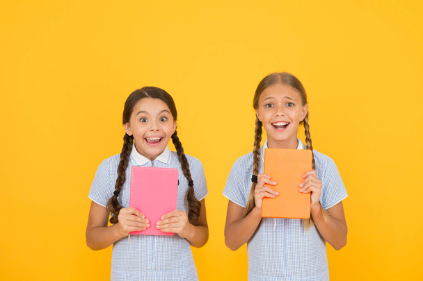 Hysterical laugh. Do not panic. Cute children reading book on yellow background. Adorable little girls learn reading copy space. Home reading and schooling. Study hard. Exam is coming. Final test - Foto, Bild