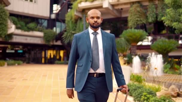 Uomo d'affari indiano con abito blu che cammina con borsa da viaggio o valigia
 - Filmati, video