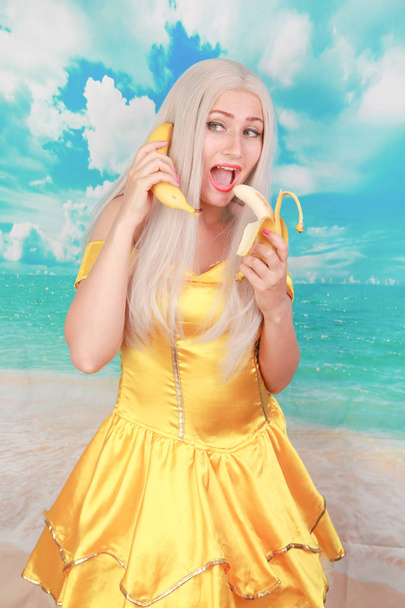 Πορτρέτο του χαρούμενο περίεργο παιχνιδιάρικο κυρία κρατώντας μπανάνα όπως το τηλέφωνο - Φωτογραφία, εικόνα