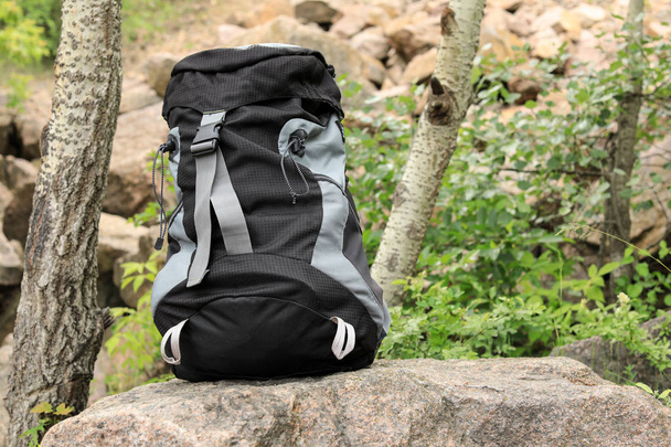 Large camping backpack on stone in forest. Space for text - Foto, immagini