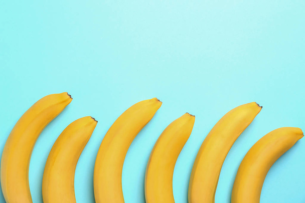 Ripe tasty bananas on blue background, flat lay - Foto, Imagem