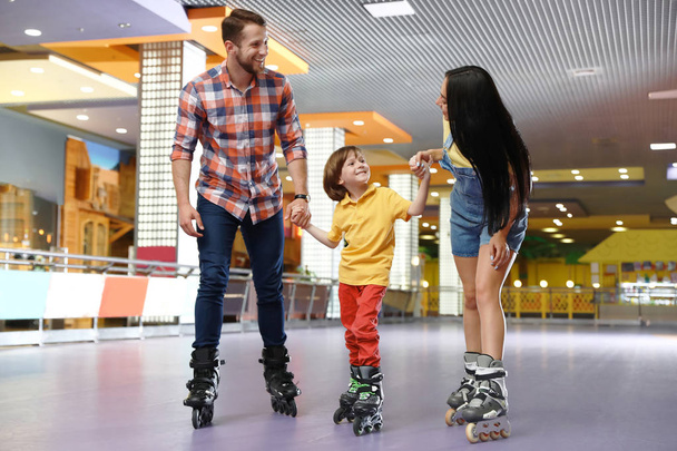 Happy family spending time at roller skating rink - Foto, Imagen