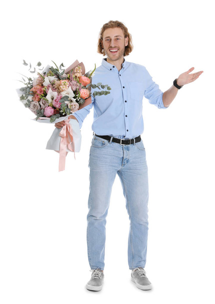 Young handsome man with beautiful flower bouquet on white background - Fotó, kép