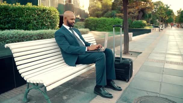 Индийский бизнесмен держит ноутбук в синем костюме возле офиса
 - Кадры, видео