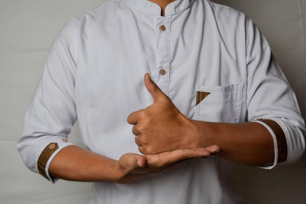 Közelről ázsiai ember mutatja kézmozdulatok ez azt jelenti, segíteni elszigetelt fehér alapon. Amerikai jelnyelv - Fotó, kép