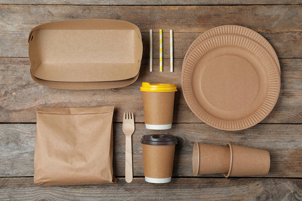 Flat lay composition with new paper dishware on wooden background. Eco life - Fotoğraf, Görsel