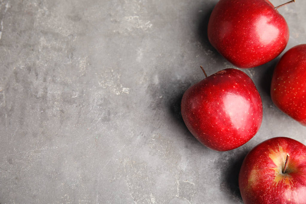 Ripe juicy red apples on grey background, flat lay. Space for text - Foto, Imagen