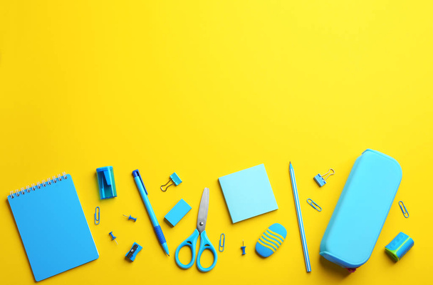 Light blue school stationery on yellow background, flat lay. Space for text - Fotó, kép