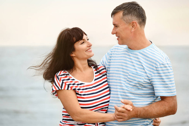 Happy mature couple spending time together on sea beach - Photo, image