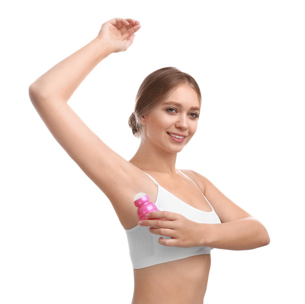 Young woman applying deodorant to armpit on white background - Valokuva, kuva