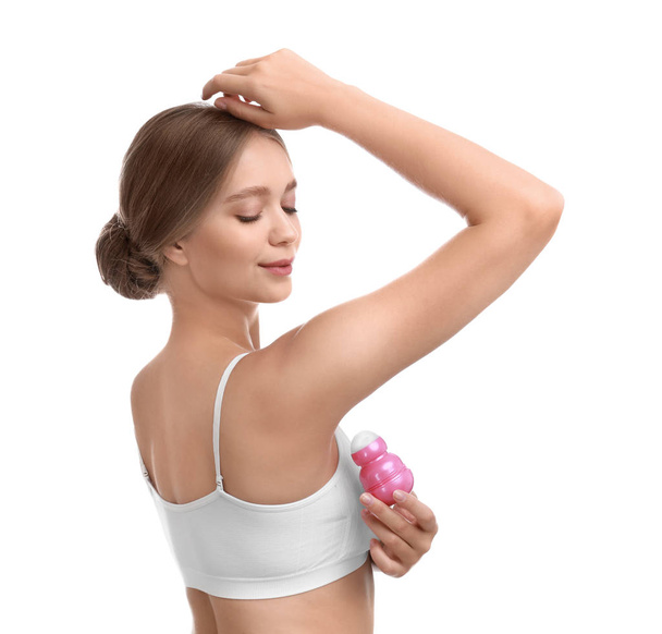 Young woman applying deodorant to armpit on white background - Valokuva, kuva