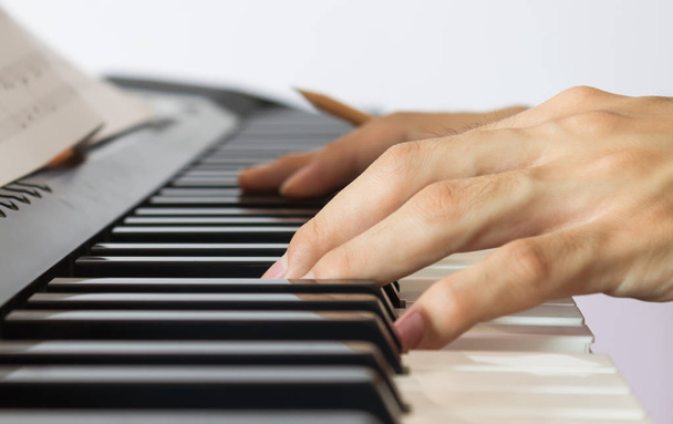 Πιάνο παίκτης χέρι στο ηλεκτρικό πιάνο με παρτιτούρες - Φωτογραφία, εικόνα