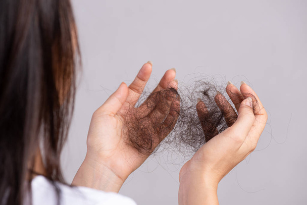 Healthy concept. Woman show her damaged long loss hair and looking at her hair on hand. - Fotoğraf, Görsel