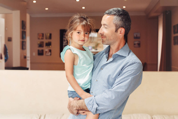 Father and daughter girl kid at home spending time together. Parent playing with child. Family people having fun hugging and laughing. Real people lifestyle. Fathers day holiday concept. - Foto, afbeelding