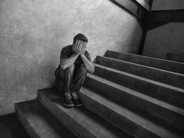 desperate man sitting outdoors on dark grunge street corner staircase feeling sick suffering depression problem and anxiety crisis in mental health concept - Photo, Image