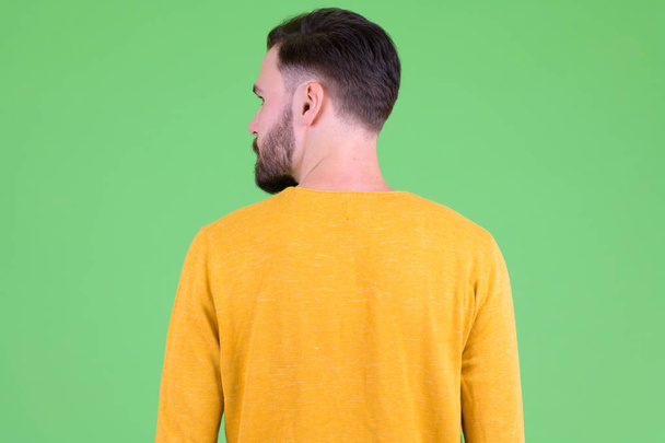 Rear view of young bearded man looking over shoulder - Foto, Imagem