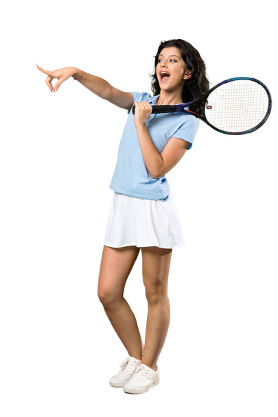 Una toma completa de una joven jugadora de tenis sorprendida y señalando con el dedo hacia un lado sobre un fondo blanco aislado
 - Foto, Imagen