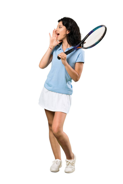 Een volledige shot van een jonge tennisser vrouw schreeuwen met mond wijd open over geïsoleerde witte achtergrond - Foto, afbeelding