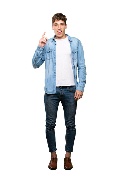 A full-length shot of a Handsome young man thinking an idea pointing the finger up over isolated white background - Valokuva, kuva