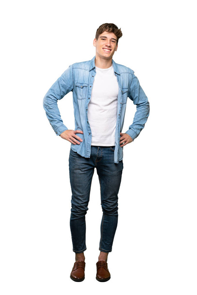 A full-length shot of a Handsome young man posing with arms at hip and smiling over isolated white background - Valokuva, kuva