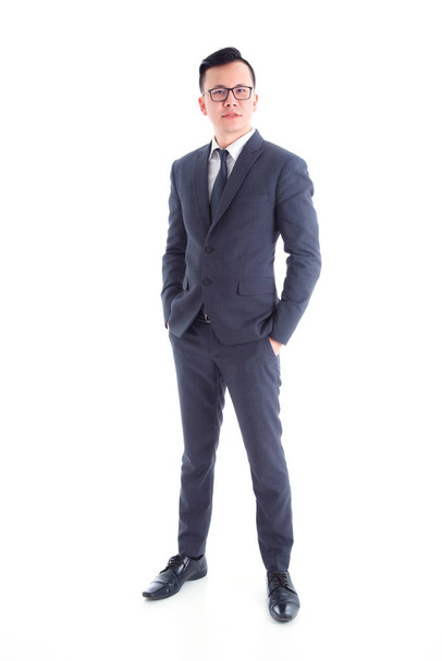 Full length of handsome asian businessman wearing suit standing  - Fotó, kép