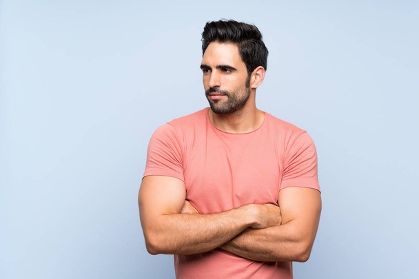 Handsome young man in pink shirt over isolated blue background portrait - Photo, Image