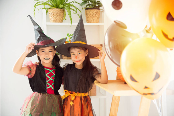 Due bambini in costume da strega in piedi e sorridono insieme
  - Foto, immagini