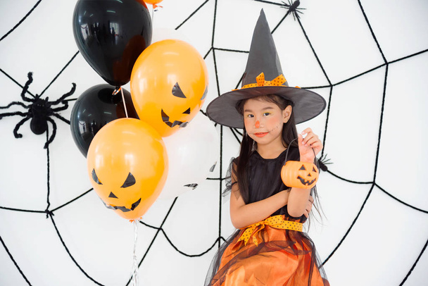 Pretty asian girl in witch costume sitting in room  - Foto, Bild