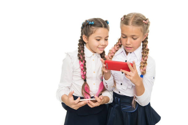 Future is here. Little schoolgirls using smartphones isolated on white. Small kids learning mobile technologies for future life. Future career with digital skills. The future of education, copy space - Фото, зображення