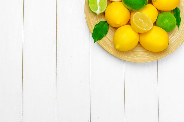 lemons and limes on a wooden background. - Valokuva, kuva