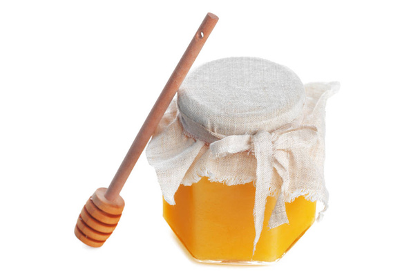Glass jar with sweet honey isolated on white background - Фото, изображение