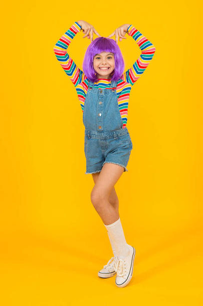 Cosplay outfit. Otaku girl in wig smiling on yellow background. Cosplay character concept. Culture hobby and entertainment. Happy childhood. Anime fan. Cosplay kids party. Child cute cosplayer - Фото, изображение