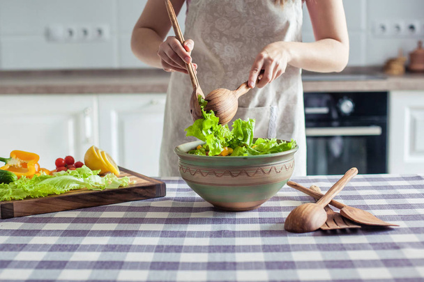 Ernährung. junge hübsche Frau in grünem Hemd steht und bereitet den Gemüsesalat in Schüssel für gute Gesundheit in der modernen Küche zu Hause, gesunder Lebensstil, Kochen, gesundes Essen - Foto, Bild