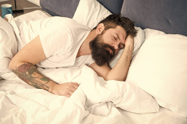 Need some rest. Sleep disorders concept. Man bearded hipster having problems with sleep. Guy lying in bed try to relax and fall asleep. Relaxation techniques. Violations of sleep and wakefulness - Photo, image