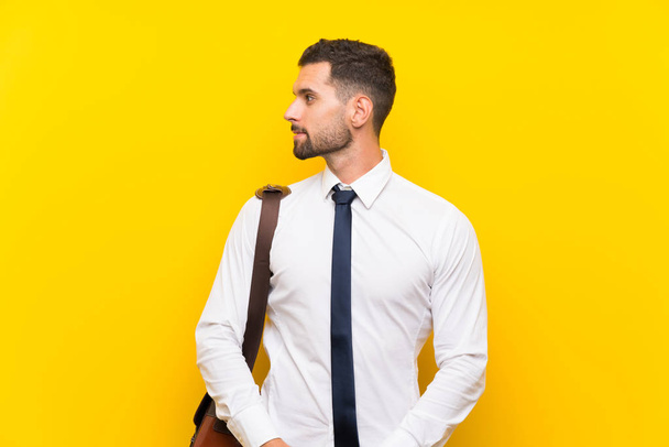 Όμορφος επιχειρηματίας πάνω από απομονωμένο κίτρινο φόντο που κοιτάζει προς την πλευρά - Φωτογραφία, εικόνα
