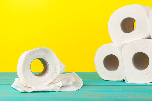 Toilet paper stacks  on bright yellow background - Foto, afbeelding