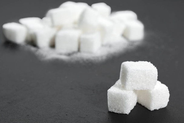 Κύβοι λευκής ζάχαρης σε μαύρο φόντο από κοντά - Φωτογραφία, εικόνα