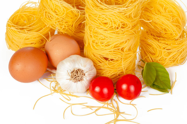 Raw tagliatelle pasta isolated on white background. - Photo, Image